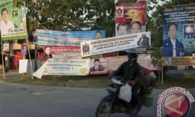 Logistik Pemasangan Baliho Proses pemasangan baliho kampanye di jalan protokol