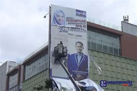 Etika Kampanye dan Masa Tenang Petugas membersihkan baliho kampanye saat masa tenang