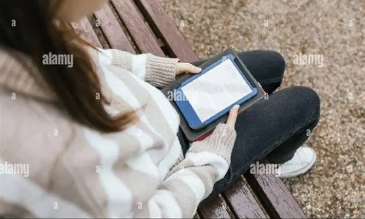 Membaca ebook di tablet saat bersantai di alam
